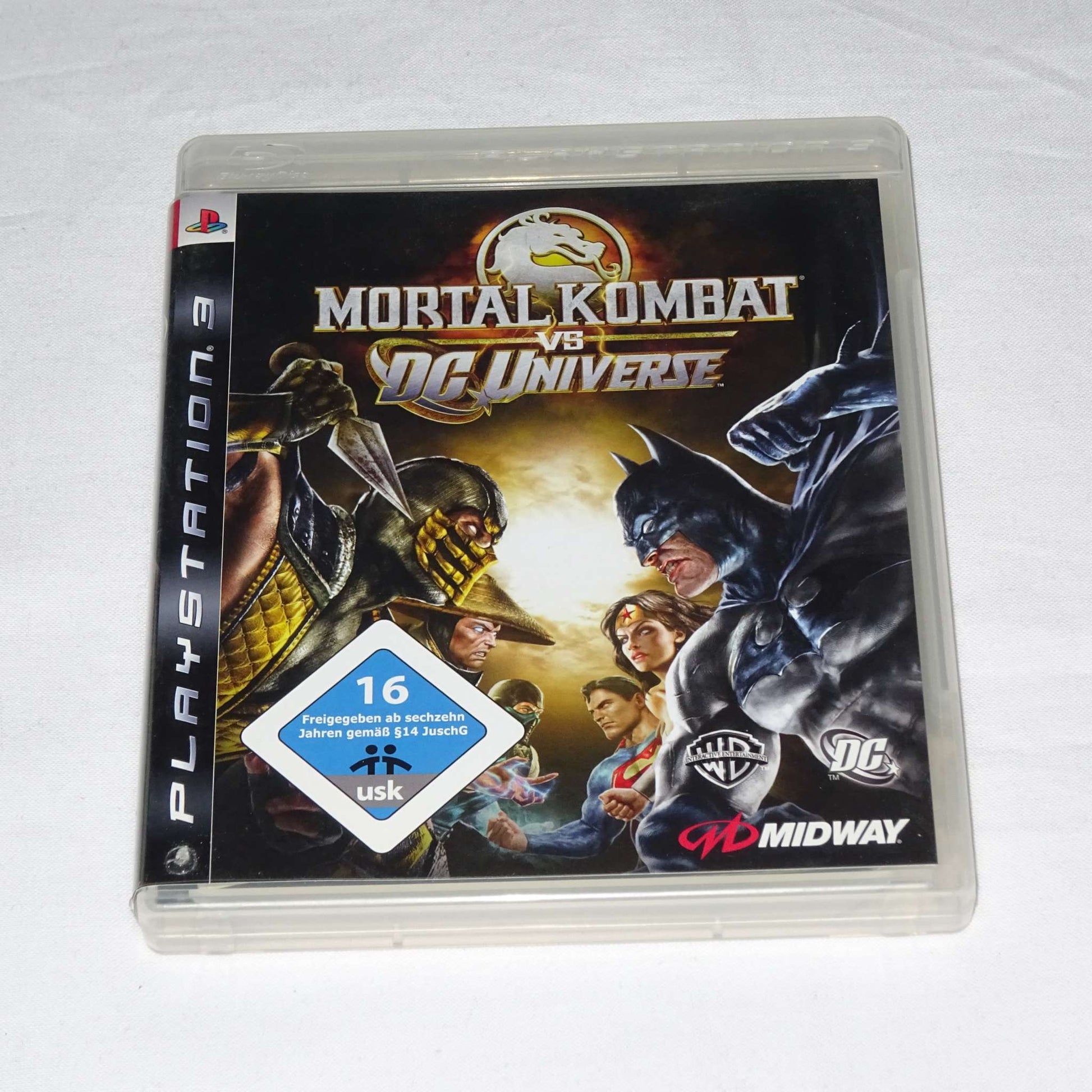 PS3 game case for "Mortal Kombat vs DC Universe" featuring characters from both franchises, used condition.