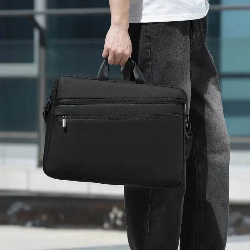 Elegant black laptop bag for men, fitting 15.6-17.3 inch devices, with adjustable shoulder strap.
