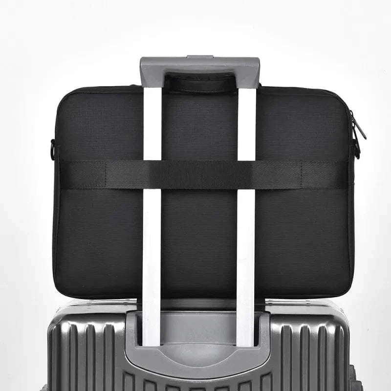Black business laptop bag with adjustable shoulder strap, fits 15.6-17.3 inch laptops, shown on suitcase handle.